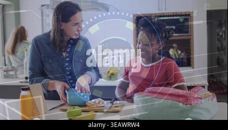 Mescolare mamma e bambino facendo uno spuntino di frutta sull'isola della cucina, tenendo in mano la ciotola blu, camicia in denim Foto Stock