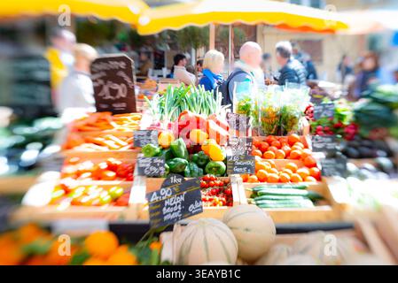 Prodotti colorati, tra cui frutta e verdura, esposti sulle bancarelle dei venditori in un mercato all'aperto Foto Stock