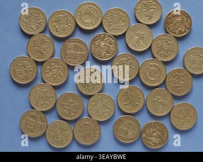Una libbra di monete denaro (GBP), valuta del Regno Unito su sfondo blu Foto Stock
