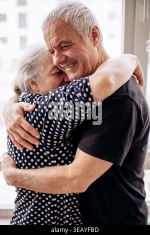 Coppia senior che condivide con gioia il tenero abbraccio Foto Stock