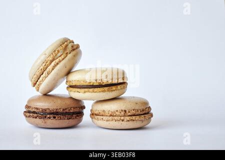 Quattro macaron francesi marroni, torte dai sapori diversi, caffè e creme brulee. Piramide di dessert fatti in casa, macaroon con vista laterale, spazio copie Foto Stock