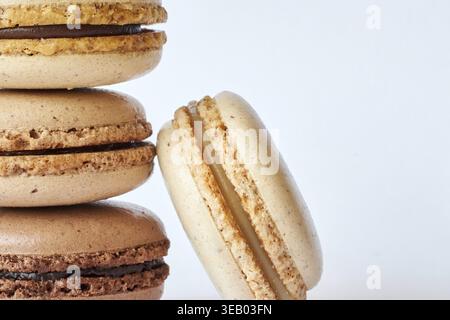 Pila di quattro macaron francesi marroni, torte dai gusti diversi, caffè e creme brulee. Piramide di dessert fatti in casa, macaron vista laterale, C Foto Stock