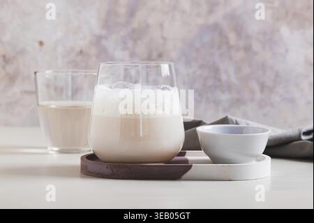 Matcha rosa nuvoloso con acqua di cocco in un bicchiere sul tavolo Foto Stock