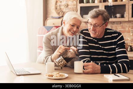 Felice coppia senior bere il tè in cucina Foto Stock