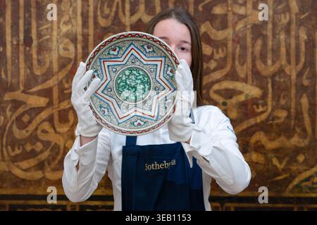 Londra, Inghilterra, Regno Unito. 24 aprile 2026. Un tecnico di Sotheby's tiene un piatto di ceramica policroma in stile Iznik, Turchia, intorno al 1950, durante una chiamata fotografica per la vendita di Arts of the Islamic World & India al Sotheby's di Londra, Regno Unito. Il pezzo è stimato in GBP 50,000-80,000. (Credit Image: © Thomas Krych/ZUMA Press Wire) SOLO PER USO EDITORIALE! Non per USO commerciale! Crediti: ZUMA Press, Inc./Alamy Live News Foto Stock
