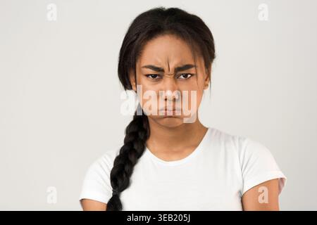 Espressione di frustrazione acquisita in un Ritratto di una giovane donna con capelli intrecciati Foto Stock