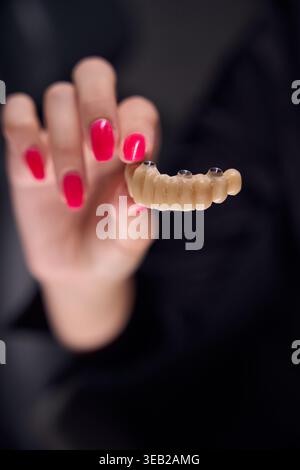 Donna adulta con protesi dentale in ambiente clinico Foto Stock