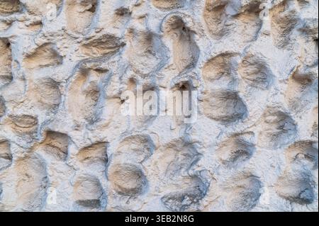 Parete decorativa in gesso con motivo a rilievo arrotondato irregolare. Foto Stock