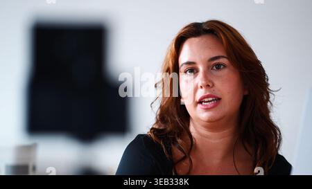 Giovane donna che parla, comunica i suoi pensieri, crea contenuti in un ambiente moderno Foto Stock
