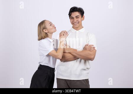 Giovane uomo e donna che sussurrano e ridono insieme Foto Stock