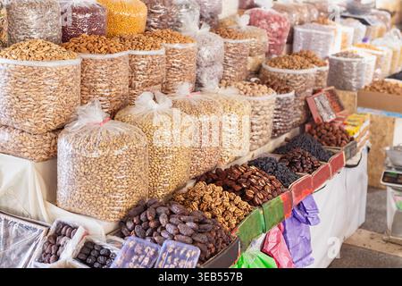 Frutta secca e frutta secca esposte in grandi sacchetti al bazar Siab di Samarcanda. Abbondante bancarelle di mercato con mandorle, pistacchi, datteri, noci e uva passa Foto Stock