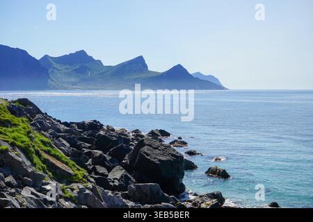 Isola di Flakstadøya vista in lontananza dal sentiero costiero vicino a Uttakleiv, Isole Lofoten, Norvegia Foto Stock