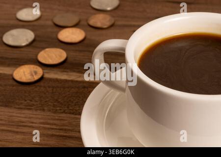 Tazza di caffè su una superficie in legno con cambio libero – concetto di spesa quotidiana Foto Stock