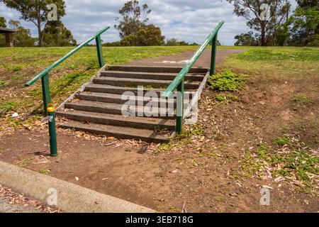 La vecchia scala in legno è verde sulla collina. Brimbank Park (Parks Victoria) Australia, Victoria, dicembre 2025. Foto Stock