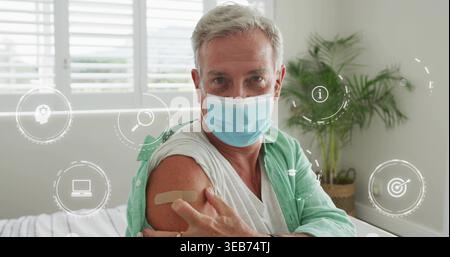 Seduto uomo anziano sul letto indossando maschera blu manica arrotolata che mostra benda e copertura medica Foto Stock