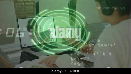 Scrivi uno studente che indossa cuffie e maglione alla scrivania, laptop con rivestimento HUD verde, spazio per le copie Foto Stock