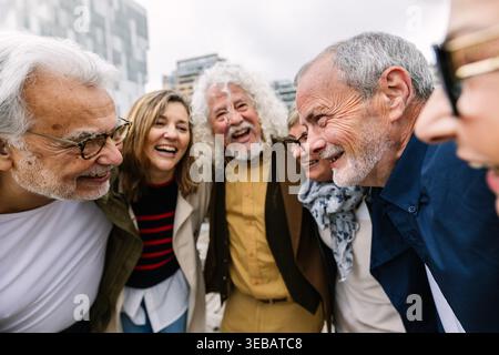 Amici anziani felici che sorridono guardando in basso insieme Foto Stock