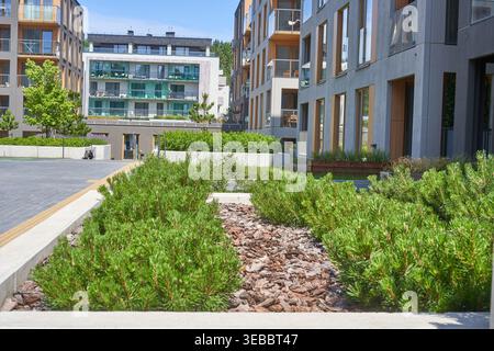 Cortile residenziale moderno con edifici residenziali contemporanei con grandi finestre, balconi in vetro e materiali misti tra cui il cemento Foto Stock