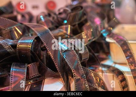 Un primo piano, fotografia macro di strisce di pellicola 35mm intrecciate con fori di regolazione visibili, che mostrano fotogrammi di pellicola sviluppati. La celluloid Foto Stock
