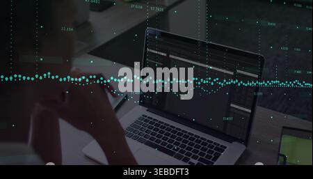 Donna in età adulta che indossa la parte superiore scura su una scrivania in legno, concentrandosi su un laptop aperto con sovrapposizione dati Foto Stock