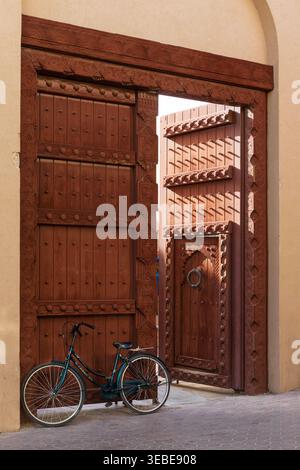 Porte d'ingresso splendidamente intagliate e ornate dell'Ufficio postale dell'Oman presso il Souq centrale di Nizwa, Oman Foto Stock