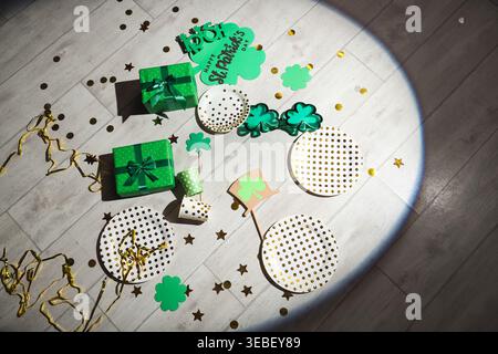 Dopo la festa, abbina regali e decorazioni per il giorno di San Patrizio su pavimento in legno Foto Stock