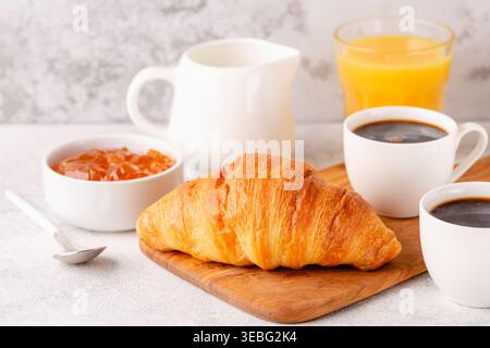 Caffè caldo, croissant su sfondo chiaro, messa a fuoco selettiva. Colazione Foto Stock