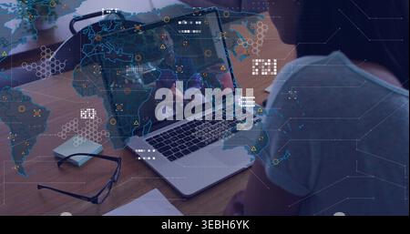 Visualizzazione dello schermo del laptop che mostra il team durante una chiamata remota alla scrivania, occhiali color verde acqua sovrapposizione mappa del mondo Foto Stock