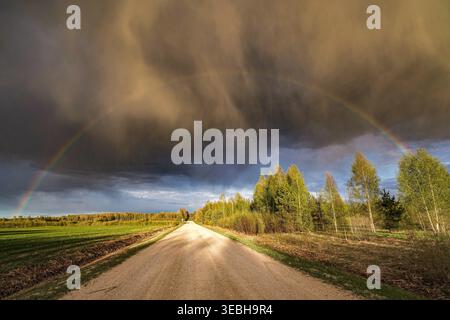 Arcobaleno sopra una strada di campagna Foto Stock