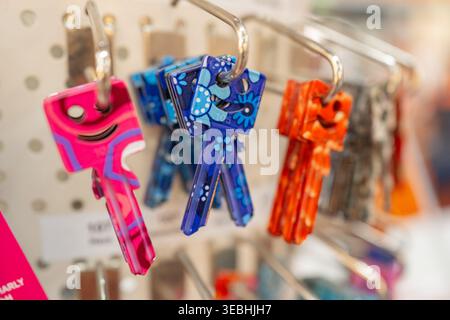 Primo piano di duplicati colorati appesi in un negozio. Varietà di forme e colori che rappresentano i servizi di fabbro e le soluzioni di sicurezza. Foto Stock