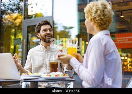 Coppia che gusta un pasto al Cafe' all'aperto Foto Stock