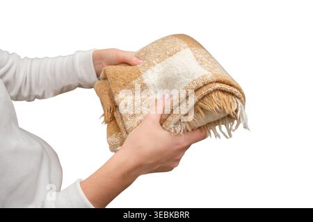 Donna che tiene in mano una coperta morbida a quadri beige. Mani che trasportano un accessorio di lana a scacchi calda. Articoli tessili per la casa, elementi di design per interni e per la casa c Foto Stock