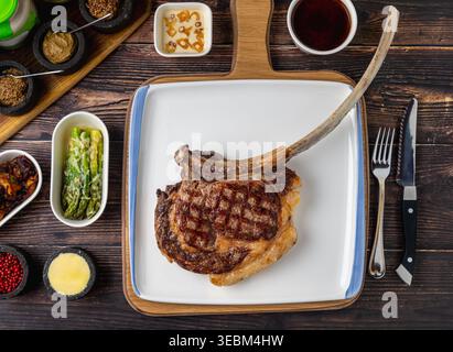 Bistecca di manzo Tomahawk con spezie servita su un tavolo rustico Foto Stock