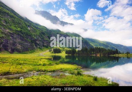 Splendido paesaggio lacustre estivo con montagne nelle Alpi Autria. Un posto meraviglioso per le escursioni. Lago alpino con alte montagne. Pini. Hohe Tauern vicino Foto Stock