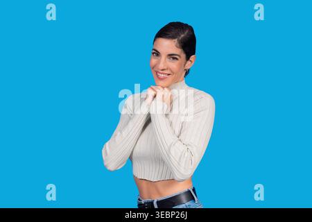 Donna che si sente felice, esprimendo gioia con un ampio sorriso e mani insieme Foto Stock