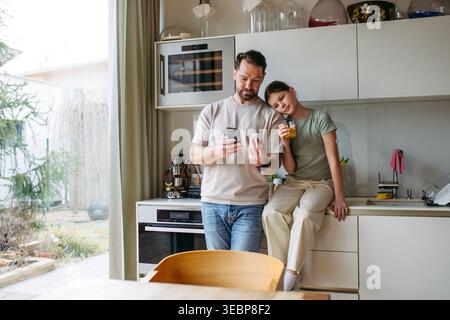 Papà con figlia con diabete in cucina a casa. Foto Stock