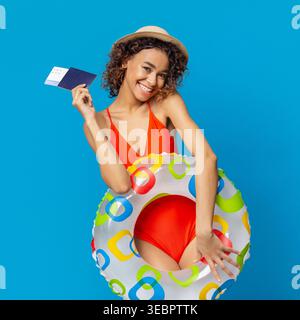 Giovane donna in costume da bagno con passaporto e godendo delle vacanze estive in piscina Foto Stock