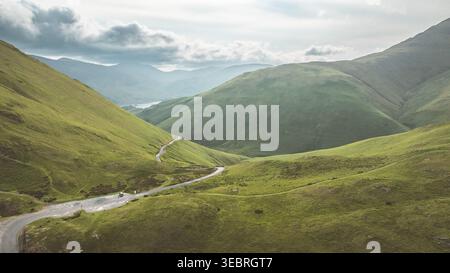 Una strada tortuosa serpeggia attraverso colline ondulate, offrendo una vista mozzafiato del paesaggio circostante Foto Stock