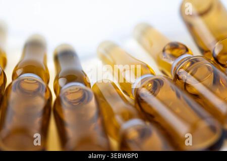 Macro shot di diverse fiale farmaceutiche disposte in un motivo curvo su bianco Foto Stock