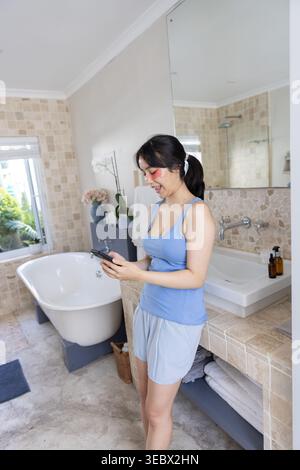 Vasca da bagno seduto sotto la finestra con vista sul verde, stanza da bagno piastrellata a mosaico, spazio fotocopie Foto Stock