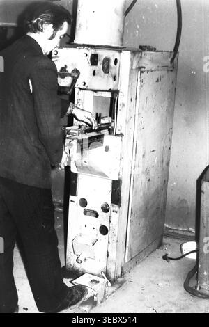 Sloviansk, 1986 anni. Un lavoratore gestisce una pressa meccanica industriale o una macchina di stampaggio all'interno delle officine di riparazione del deposito municipale dei filobus. L'uomo preleva un pedale per controllare l'attrezzatura pesante mentre posiziona con cura un componente con le mani. Questo macchinario specializzato è essenziale per la fabbricazione e la riparazione di parti metalliche per mantenere operativa la flotta di trasporto della città. Questa autentica fotografia d'archivio documenta i processi industriali, gli standard di sicurezza e il lavoro quotidiano di un lavoratore sovietico in un tranquillo Donbas. Foto Stock