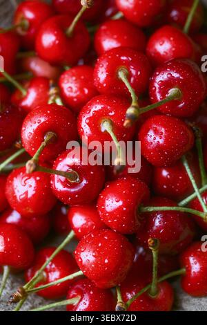 Primo piano di ciliegie con goccioline d'acqua. Consistenza fresca e succosa di frutta rossa, concetto di raccolta estiva Foto Stock