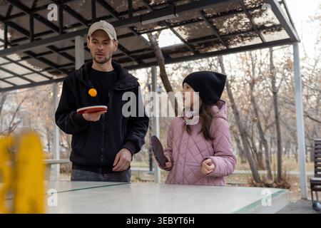 Padre e figlia si sono concentrati sul gioco di ping pong Foto Stock