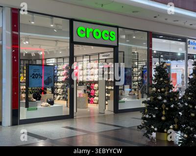 Cracovia, Polonia - 3 dicembre 2025: Vista interna di un negozio al dettaglio Crocs con un'ampia varietà di calzature colorate e mostre promozionali Foto Stock