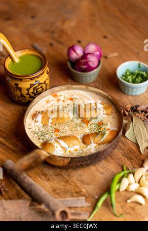 Una presentazione completa e attraente di un delizioso curry kofta vegetariano indiano in una padella rustica. Serve elegantemente con condimenti freschi, offerta Foto Stock