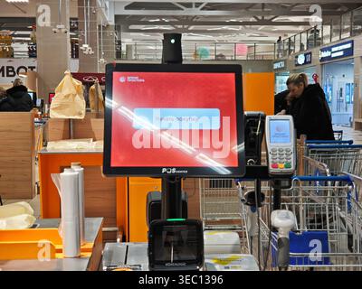 Kirov, Russia - 8 febbraio 2026: Il terminale self-checkout è pronto con un messaggio per i clienti. Gli acquirenti sono presenti nel supermercato pronti a prepararsi Foto Stock