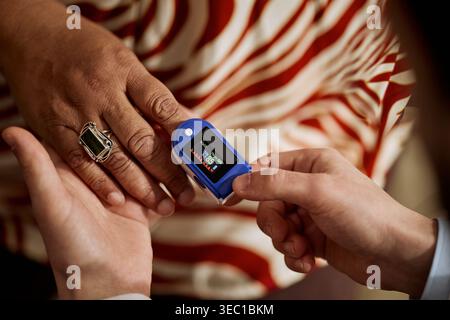 Donna di mezza età sottoposta al check-in del pulsossimetro Foto Stock