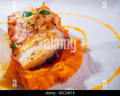 Polpo arrosto da buongustai con cremose patate dolci schiacciate e asparagi freschi, raffinato stile gastronomico. Foto Stock