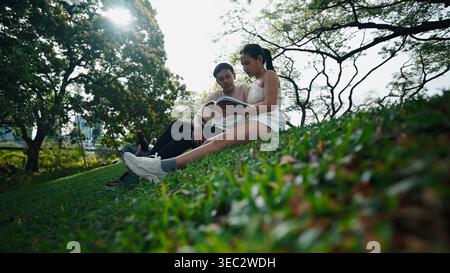 Gli studenti si godranno un pomeriggio rilassante leggendo insieme in un lussureggiante parco verde Foto Stock