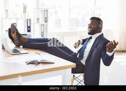 Giovane imprenditore rilassato divertirsi in ufficio Foto Stock